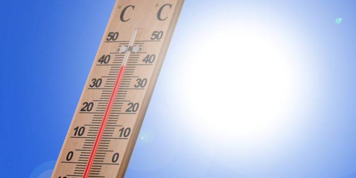 Ein Thermometer zeigt eine hohe Temperatur vor der Sonne und symbolisiert so die Hitzewarnung.