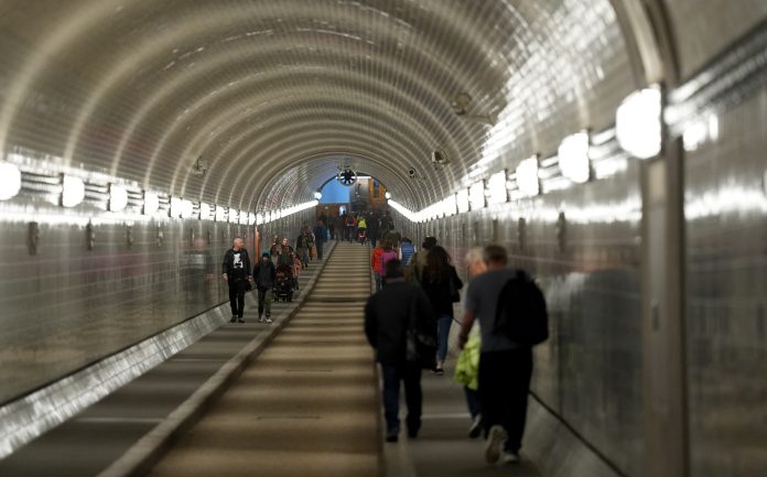 Passant*innen laufen durch den Alten Elbtunnel Passant*innen laufen durch den Alten Elbtunnel.