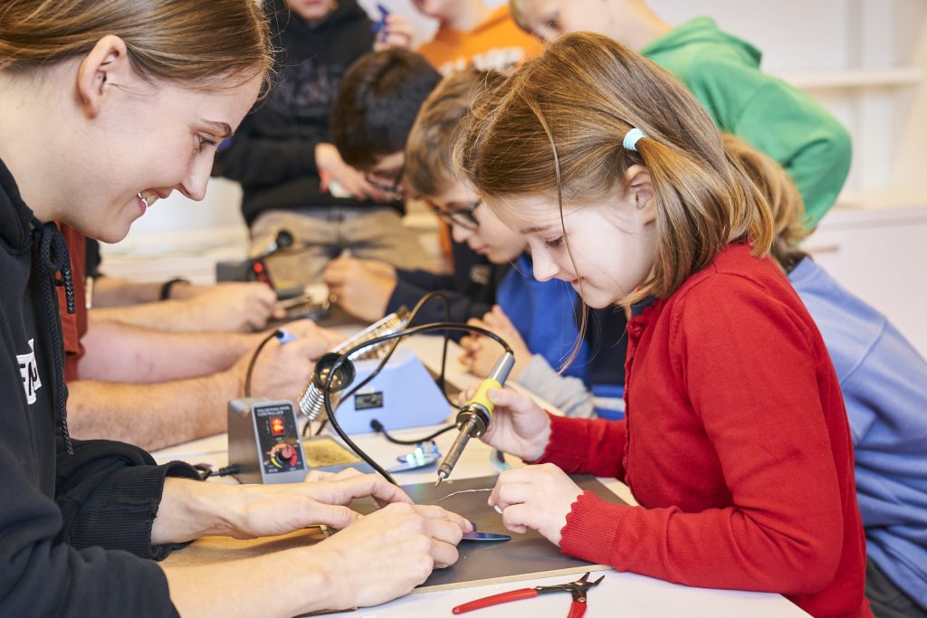 Vier Kinder tüfteln an Technik.