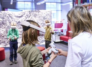Kreativ Technik und KI entdecken Ein Kind hat eine Virtual-Reality-Brille auf dem Kopf und einen Controller in der Hand. Grund dafür ist die Auftaktveranstaltung der Code Week Hamburg in der Hamburger Bücherhalle.