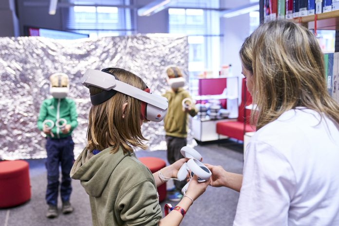 Auftaktveranstaltung der Code Week Hamburg 2025 Ein Kind hat eine Virtual-Reality-Brille auf dem Kopf und einen Controller in der Hand. Grund dafür ist die Auftaktveranstaltung der Code Week Hamburg in der Hamburger Bücherhalle.
