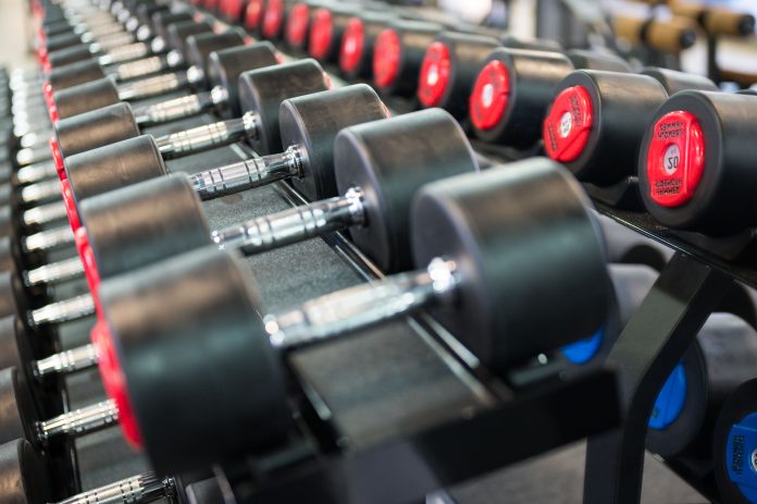 Fitnessstudio Reihe von Hanteln in einem Fitnessstudio, ordentlich auf einem Hantelständer angeordnet.