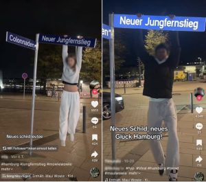 Ein Mädchen und ein Junge hängen an dem Straßenschild "Neuer Jungfernstieg". Sie Tragen beide eine graue Jogginghose.