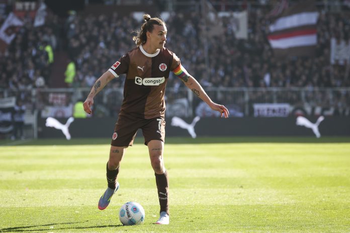 Jackson Irvine steht im St. Pauli Trickot auf dem Fußballplatz.