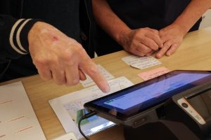 Das Touchpad einer Kasse wird bedient.