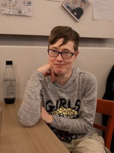 Eine Frau mit Brille sitzt an einem Tisch.