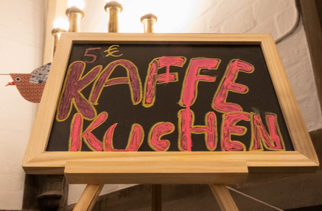 Schild mit Aufschrift Kaffe und Kuchen.