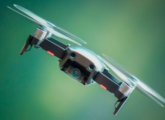 Polizei setzt erstmals Drohnen an Halloween ein Eine Drohne die vor einem grünen Hiintergrund schräg durch die Luft fliegt.