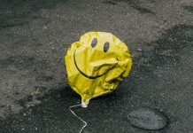 Wie zufrieden ist Hamburg wirklich? Ein zerknitterter gelber Luftballon mit einem Smilely liegt auf der Straße