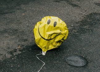 Wie zufrieden ist Hamburg wirklich? Ein zerknitterter gelber Luftballon mit einem Smilely liegt auf der Straße