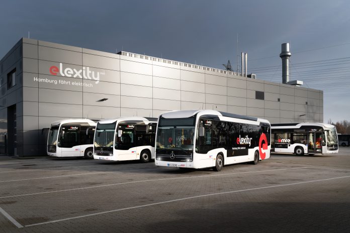 vhh_elexity_e-citaros Elektrobusse von vhh.mobility auf dem Betriebshof Bergedorf stehen vor einer gruaen Halle mit der Aufschrift
