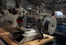 3D-Druck-Führerschein: Quietscheentchen und Brettspielpuppen Ein 3D-Drucker steht auf einem Tisch vor einer Glaswand.