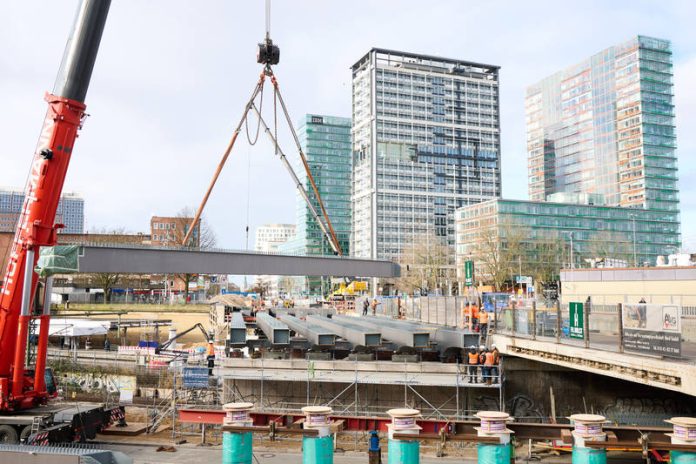 Einhub der Stahlträger an der Berlinertordammbrücke Bei den Arbeiten an der Berlinertordammbrücke wird ein Stahlträger mithilfe eines Krans angehoben.