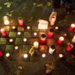Frau wird beim Reinigen eines Stolpersteins angegriffen Angezündete rote Kerzen und Blumen stehen am Gedenktag an die Pogromnacht neben Stolpersteinen.