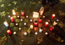 Frau wird beim Reinigen eines Stolpersteins angegriffen Angezündete rote Kerzen und Blumen stehen am Gedenktag an die Pogromnacht neben Stolpersteinen.