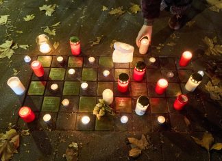 Frau wird beim Reinigen eines Stolpersteins angegriffen Angezündete rote Kerzen und Blumen stehen am Gedenktag an die Pogromnacht neben Stolpersteinen.