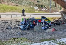 Gesundheitszustand obdachloser Menschen verschlechtert sich Obdachlose Menschen haben sich unter der Kersten-Miles-Brücke an der Helgoländer Allee ein Lager eingerichtet. Im Hintergrund fährt ein fahrradfahrer auf der Straße. Im Vordergrund sind die persönlichen gegestände obdachloser Menschen zu sehen. Darunter Koffer, Einkaufswägen, Klamotten und gefüllte Tüten.