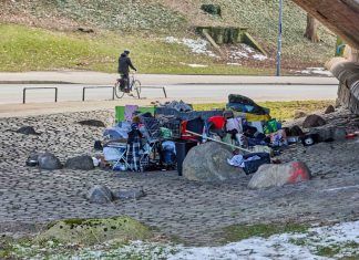 Gesundheitszustand obdachloser Menschen verschlechtert sich Obdachlose Menschen haben sich unter der Kersten-Miles-Brücke an der Helgoländer Allee ein Lager eingerichtet. Im Hintergrund fährt ein fahrradfahrer auf der Straße. Im Vordergrund sind die persönlichen gegestände obdachloser Menschen zu sehen. Darunter Koffer, Einkaufswägen, Klamotten und gefüllte Tüten.