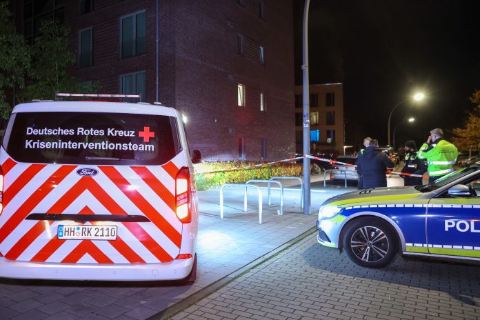 Polizei findet Verletzten - Fahndung nach Mann mit Waffe Schüsse in der Tatnacht: Ein Polizeiauto und ein Auto vom Deutschen Roten Kreuz zur Kriseninventation.