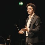 Dirigent Emanuel Meshvinski Ein Dirigent steht auf der Bühne.