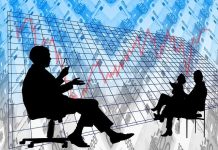 Klima, Trump, Resilienz: Ein Tag zur Wirtschaft der Zukunft Ein Symbodbil. Vorne sitzen zwei schwarz ausgemalte Figuren, einander zugewandt. Der Hintergrund ist blau mit Graphen und lässt auf Wirtschaftszahlen schließen.