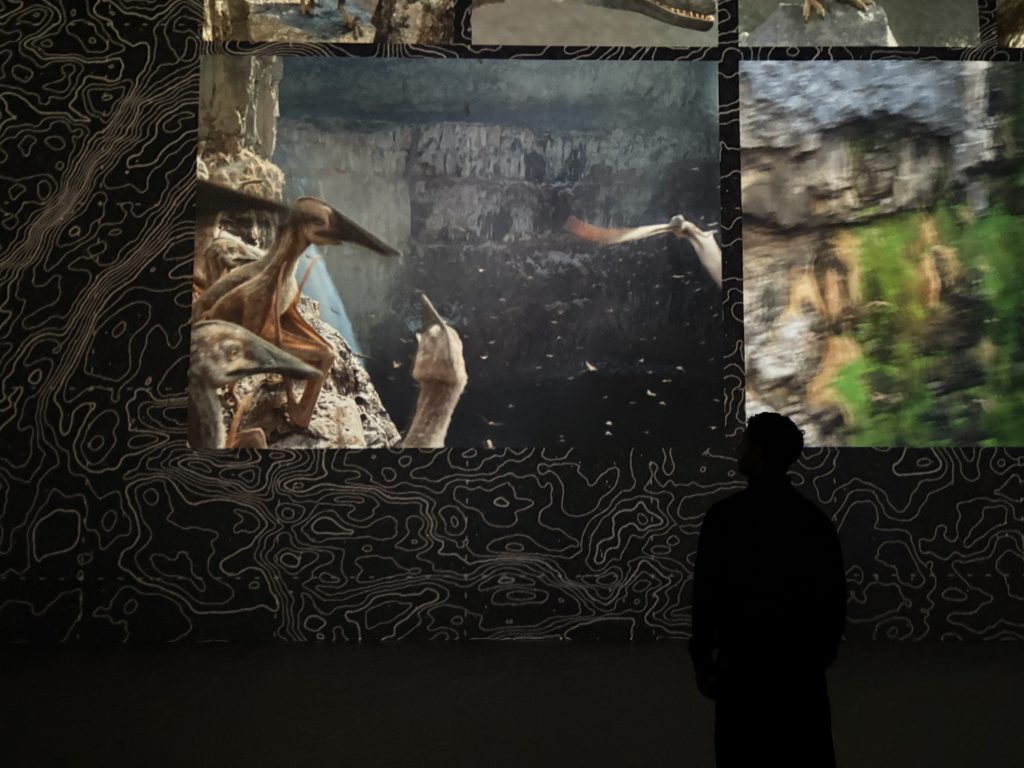 Mann vor Leinwand mit Dinos