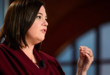 Fegebank: Spirale der Gewalt beenden Das Bild zeigt eine Frau mit dunklen Haaren und einer roten Bluse. Sie befindet sich auf der linken Seite des Bildes, schaut nach rechts und ist von der Seite fotografiert.