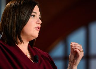 Fegebank: Spirale der Gewalt beenden Das Bild zeigt eine Frau mit dunklen Haaren und einer roten Bluse. Sie befindet sich auf der linken Seite des Bildes, schaut nach rechts und ist von der Seite fotografiert.