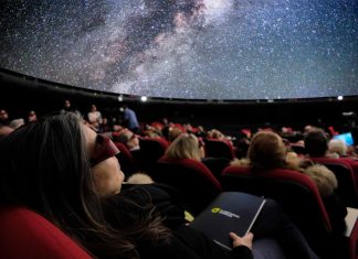 „MindSpace” – Der innere Kosmos Zu sehen sind Personen auf ihren Sitze im Sternensaal des Planetariums. Sie schauen mit 3D-Brillen auf die Projektionsfläche. Auf der Projektionsfläche der Kuppel ist ein Teil eines Universums zu sehen.