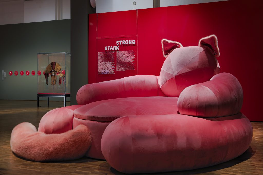 Roter Katzensessel vor Museumswand