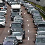Mehr Verkehr in den Weihnachtsferien erwartet Auf dem Bild stehen Autos dreispurig im Stau. Auch ein LKW und ein Wohnmobil sind zu sehen.