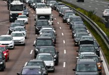 Mehr Verkehr in den Weihnachtsferien erwartet Auf dem Bild stehen Autos dreispurig im Stau. Auch ein LKW und ein Wohnmobil sind zu sehen.