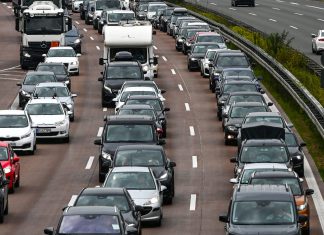 Mehr Verkehr in den Weihnachtsferien erwartet Auf dem Bild stehen Autos dreispurig im Stau. Auch ein LKW und ein Wohnmobil sind zu sehen.
