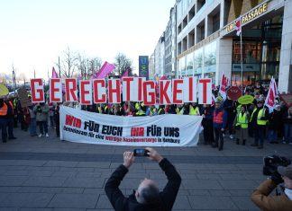 Verdi ruft in Hamburg zum Warnstreik auf Teilnehmende eines Warnstreiks halten große rote Buchstaben hoch, auf denen Gerechtigkeit steht