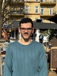 Junger Mann lächelt in die Kamera.