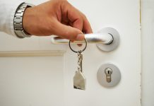 Mietwucher: Hunderte Verdachtsfälle unbearbeitet Schlüssel in einer Hand, die gerade eine Türklinke hält