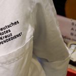 Engpässe bei Blutspende-Vorräten Der Brustberech eines Arztkittels. Zu erkennen sind die Wörter "Deutsches Rotes Kreuz Blutspendedienst" in rot.