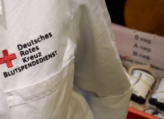 Engpässe bei Blutspende-Vorräten Der Brustberech eines Arztkittels. Zu erkennen sind die Wörter "Deutsches Rotes Kreuz Blutspendedienst" in rot.