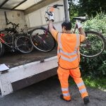 Immer mehr Schrottfahrräder in Hamburg Ein Mann hebt ein Fahrrad in einen Anhänger, um es zu entsorgen.