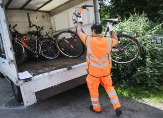 Immer mehr Schrottfahrräder in Hamburg Ein Mann hebt ein Fahrrad in einen Anhänger, um es zu entsorgen.
