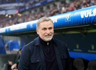 HSV-Aufsichtsrat: Vorwürfe gegen Kuntz Grund für Trennung Ein älterer Mann (Stefan Kuntz) steht vor einem HSV-Banner in einem Fußballstadion.