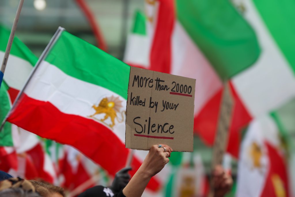 Ein Schild wird von einer Demonstrantin hochgehalten.