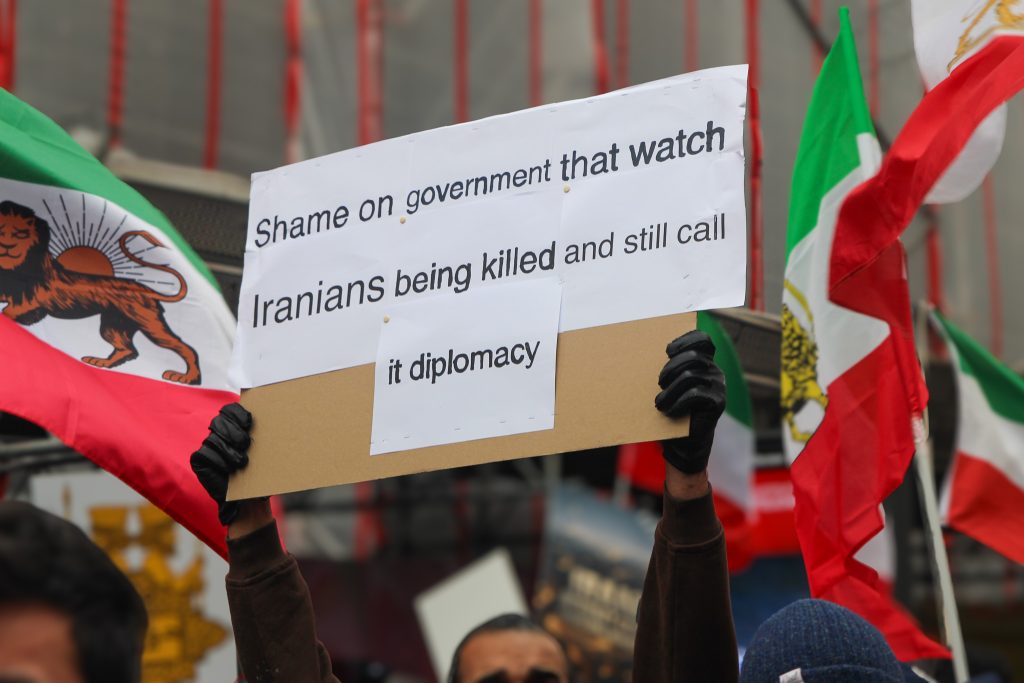 Auf einer Demonstration wird ein Schild hochgehalten.