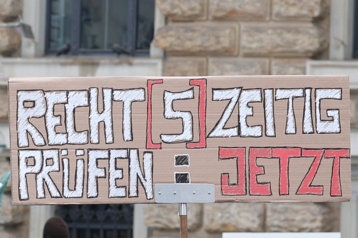 Ein Demoschild mit der Aufschrift: Recht[s]zeitig Prüfen. Jetzt.
