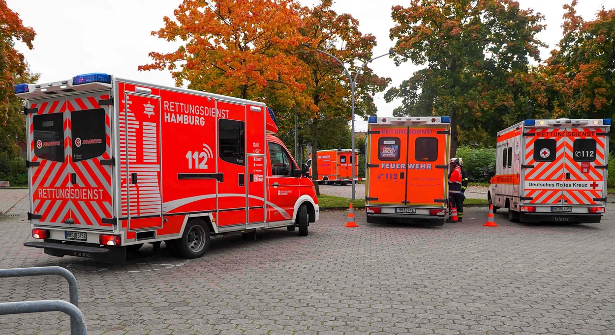 Auf dem Bild sieht man drei Rettungswägen auf einem Parkplatz. Einder davon parkt gerade aus. Im Hintergrund sieht man herbstlich gefärbte Bäume.