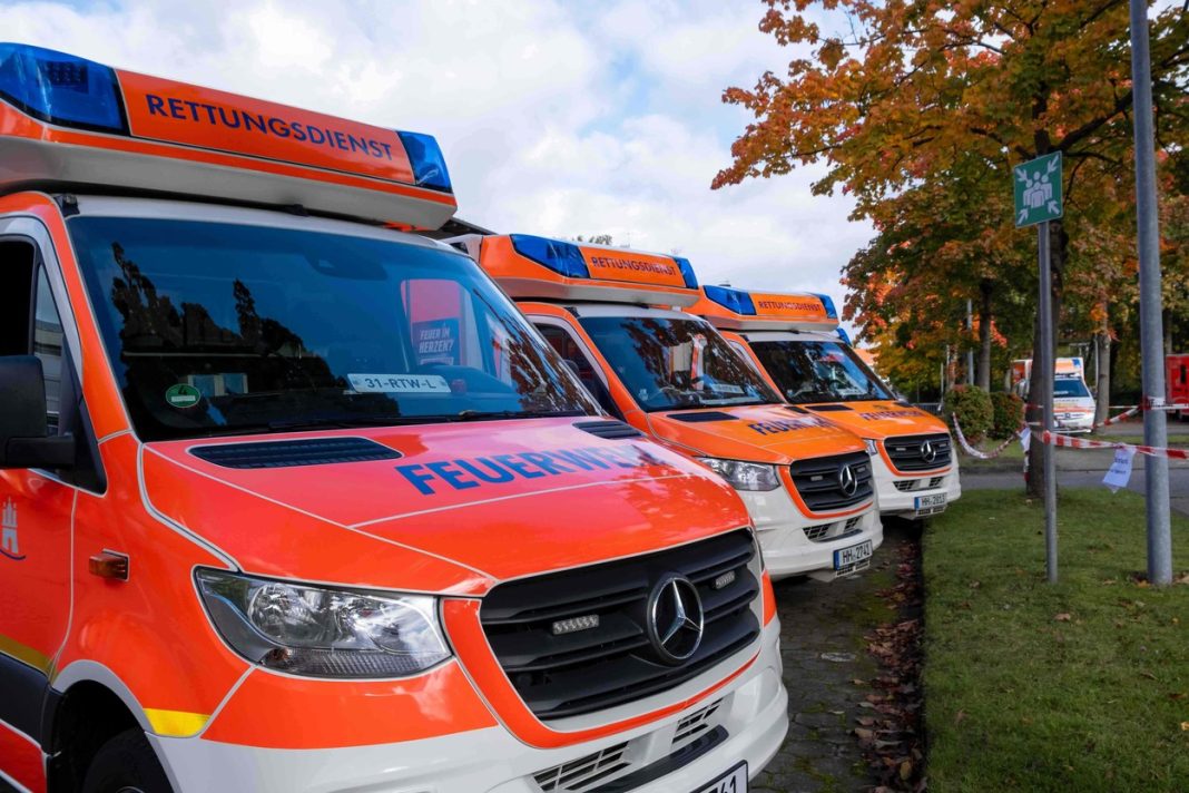 Auf dem Bild sind die vorderen Teile von drei Rettungswägen zu sehen. Sie sind parallell nebeneinander geparkt. Auf der Kühlerhaube steht jeweils Feuerwehr, auf dem Sirenenblock steht Rettungsdienst.