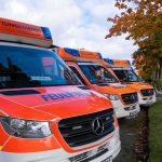 Hinter den Kulissen eines simulierten Ernstfalls Auf dem Bild sind die vorderen Teile von drei Rettungswägen zu sehen. Sie sind parallell nebeneinander geparkt. Auf der Kühlerhaube steht jeweils Feuerwehr, auf dem Sirenenblock steht Rettungsdienst.