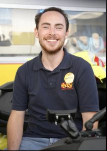 Ein junger Mann in Sanitäter-Uniform im Porträt.