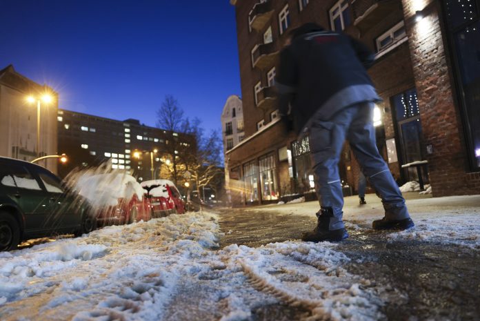 Winterwetter in Hamburg Person geht im Dunkeln durch den Schnee.