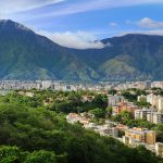 „Diejenigen, die noch an der Macht sind, stehlen uns die Hoffnung“ Das Bild zeigt die Haupstadt Venezuelas, Caracas. Sie ist umgeben von einem Gebirge.